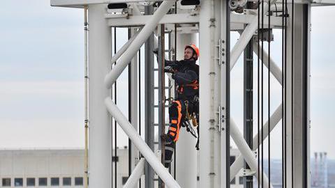 Ein Höhenretter klettert in einem Gerüstturm 