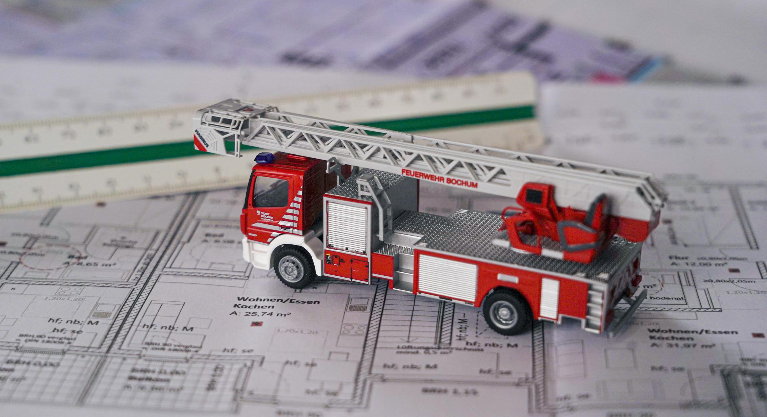 Bauzeichnung mit Lineal und einem Modell-Feuerwehrfahrzeug