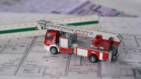 Bauzeichnung mit Lineal und einem Modell-Feuerwehrfahrzeug