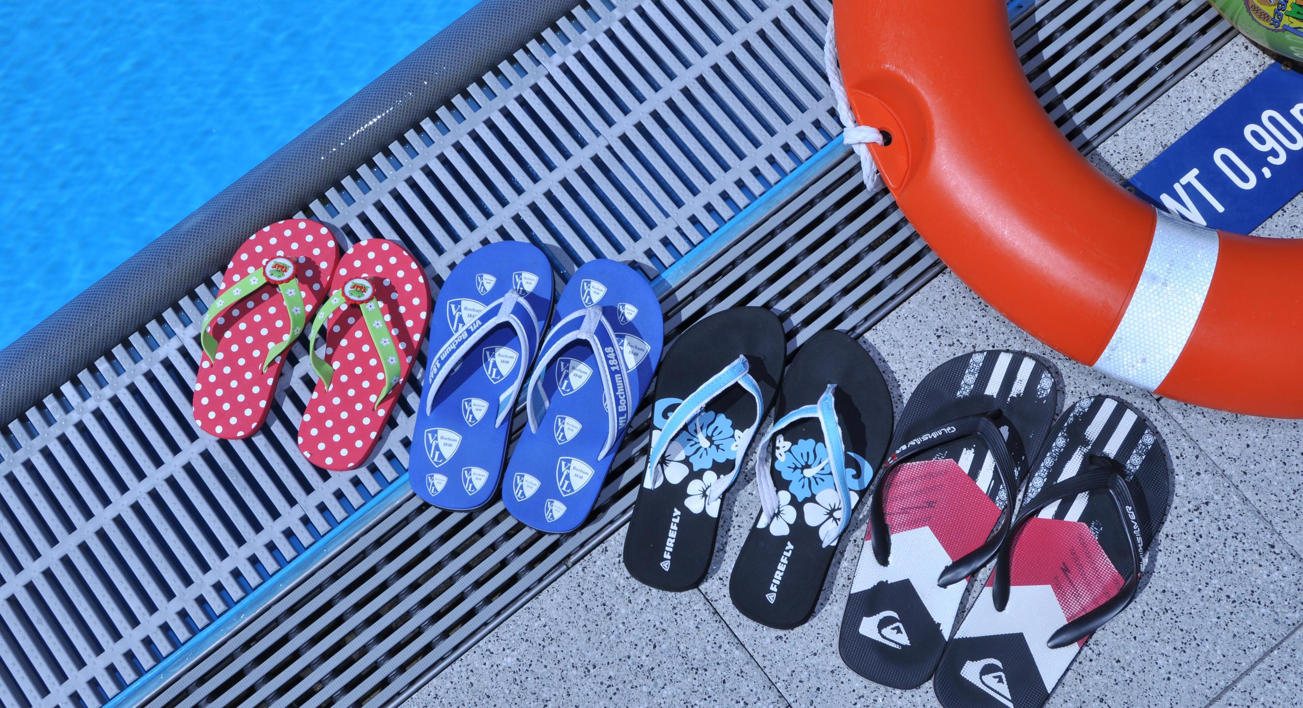 Flip-Flops stehen am Beckenrand aufgereiht im Ostbad in Bochum.