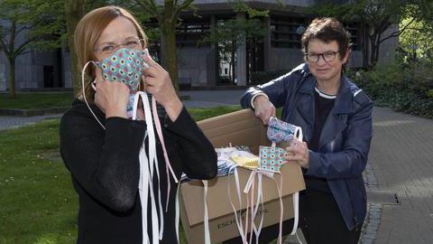 Britta Brodda, Kostümdirektorin des Bochumer Schauspielhauses (links) übergibt die genähten Masken an Britta Anger, Krisenstabsleiterin (rechts)