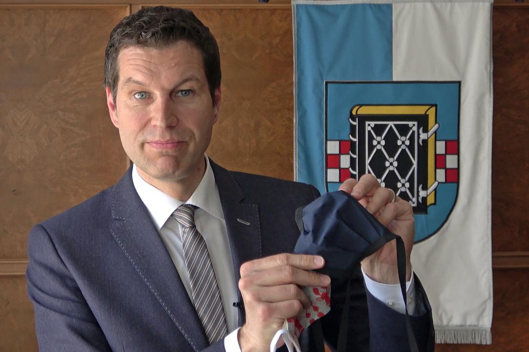 Oberbürgermeister Thomas Eiskirch zeigt eine Mund-Nasen-Maske.