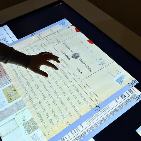 Über einen interaktiven Bildschirm werden bei einer Ausstellung im Stadtarchiv Informationen präsentiert.