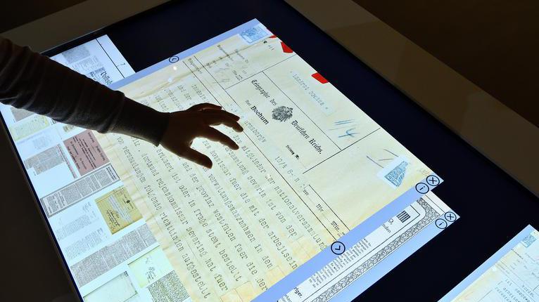 Über einen interaktiven Bildschirm werden bei einer Ausstellung im Stadtarchiv Informationen präsentiert.