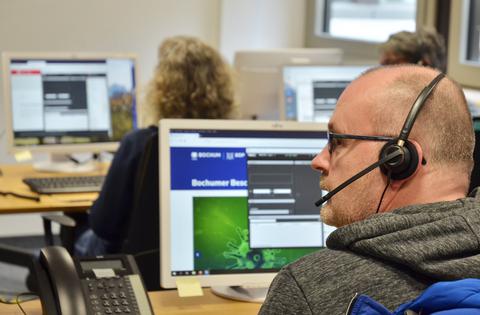 Ein Mitarbeiter der Corona-Hotline im Gespräch mit einem Anrufer.