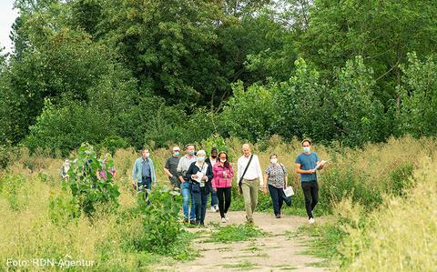 Eine Gruppe von Menschen begeht die Ostpark Flaechen