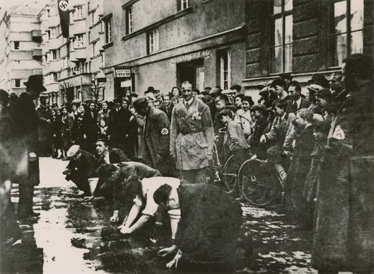 Nach der Annexion Österreichs sehen Anwohner zu, wie österreichische Nationalsozialisten Juden zwingen, den Bürgersteig zu schrubben. Wien, März 1938. Dokumentationsarchiv des österreichischen Widerstandes