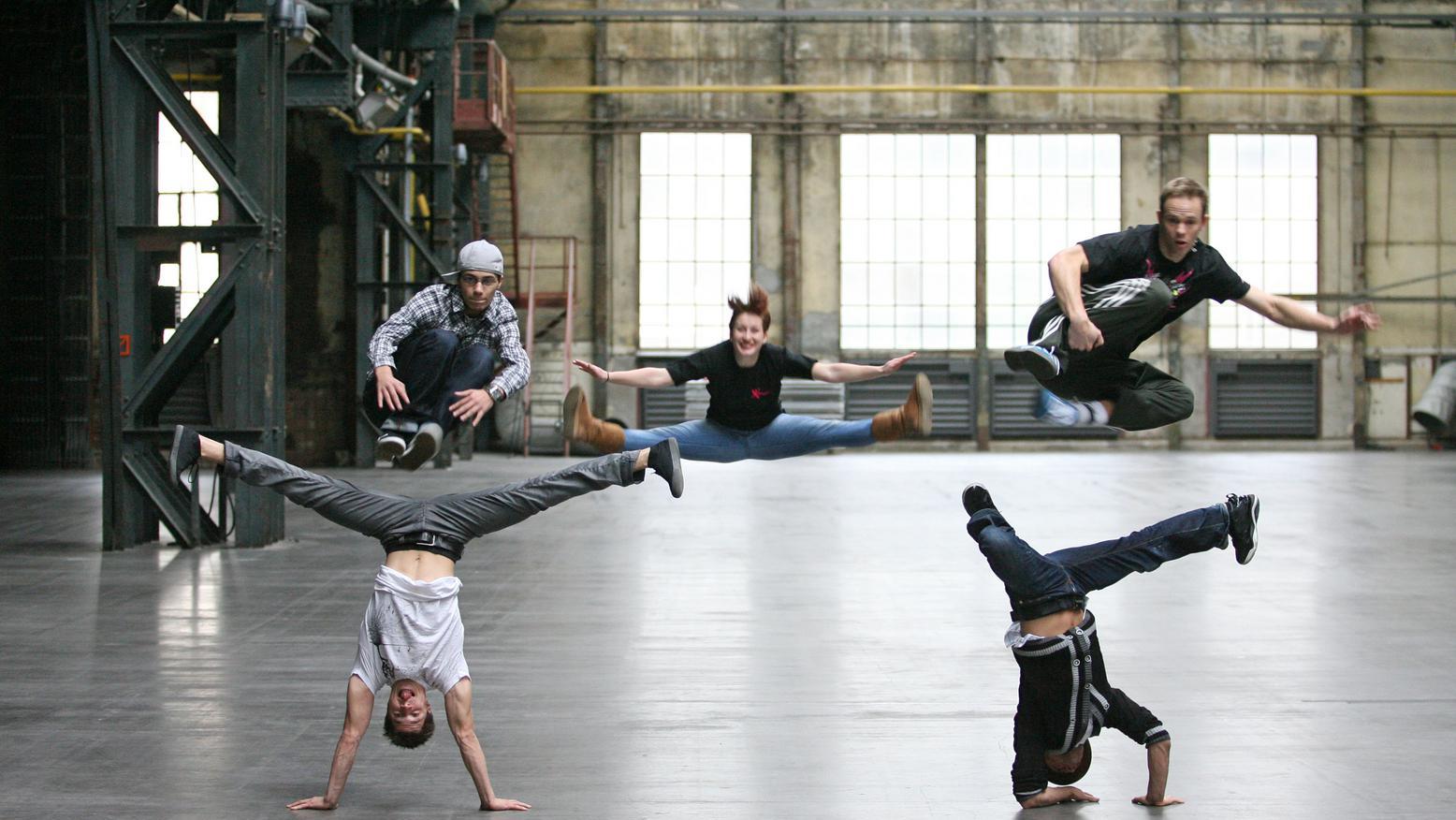 Artisten des Projekts Urbanatix in verschiedenen Körperhaltungen wie zum Beispiel Handstand oder Kopfstand.
