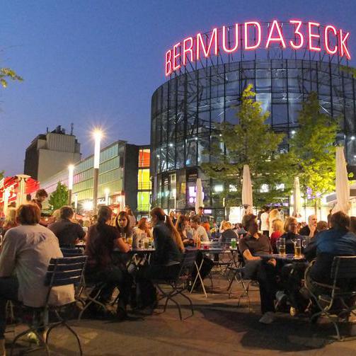 Mit Gästen besetzten Platz am Bermudadreieck in der Höhe des Parkhauses