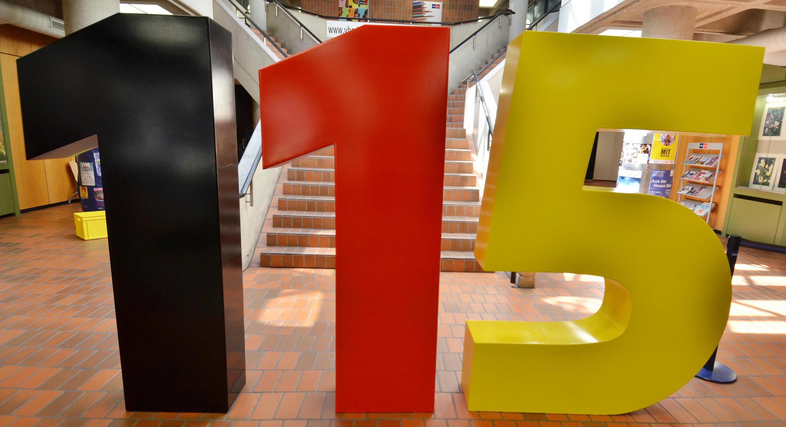 Eine 115-Skulptur wurde zum Start der einheitlichen Behördennummer 115 im VHS-Foyer aufgestellt.