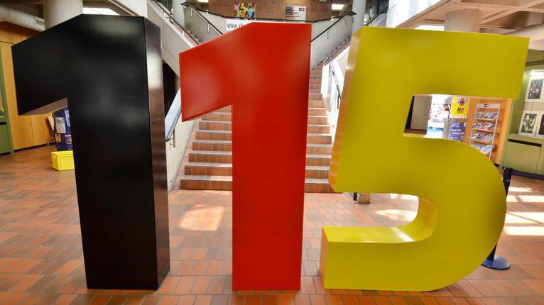 Eine 115-Skulptur wurde zum Start der einheitlichen Behördennummer 115 im VHS-Foyer aufgestellt.