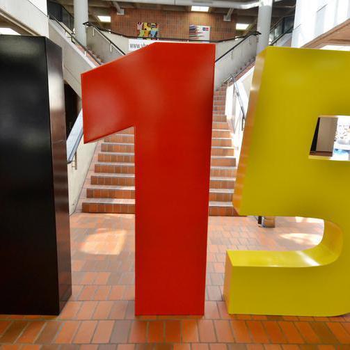 Eine 115-Skulptur wurde zum Start der einheitlichen Behördennummer 115 im VHS-Foyer aufgestellt.