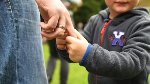 Symbolfoto zum Thema Erziehung: Ein Kind hält die Hand seines Vaters.