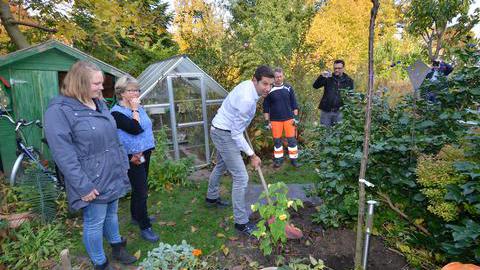 Oberbürgermeister Thomas Eiskirch pflanzt einen Apfelbaum und einen Kirschbaum.