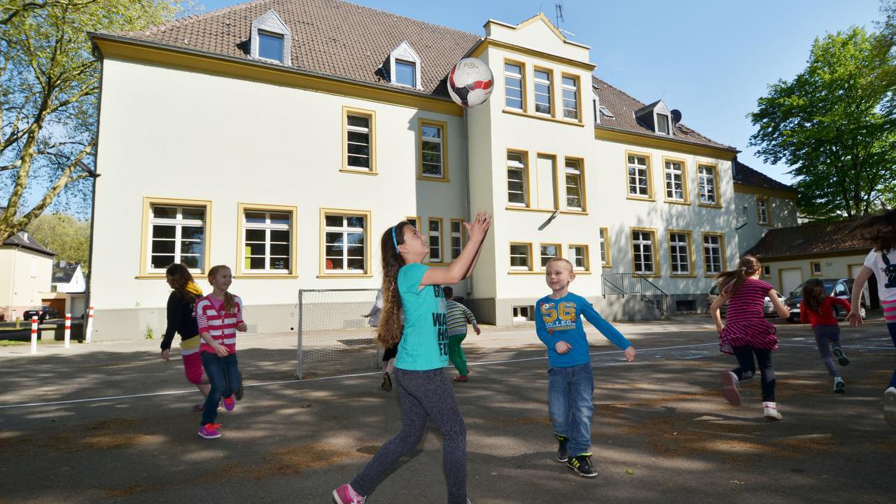 Spielende Kinder auf einem Schulhof.