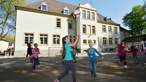 Spielende Kinder auf einem Schulhof.
