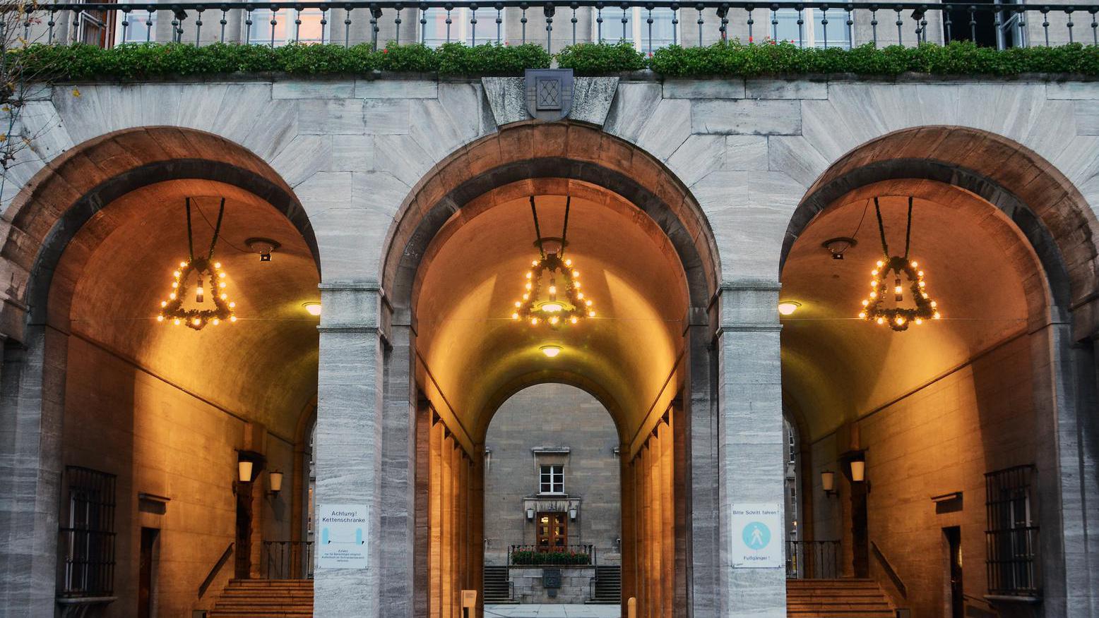 Aus Tannengrün geformte Glocken mit einer Grubenlampe, die in den Torbögen des Rathauses hängen.