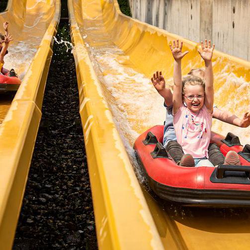Kinder in Booten auf einer Wasserrutsche