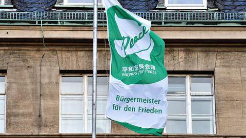 Die Fahne der Aktion "Majors for Peace - Bürgermeister für den Frieden" weht am Rathaus in Bochum.