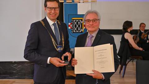 Manfred Molszich und Oberbürgermeister Thomas Eiskirch mit dem verliehenen Ehrenring und der zugehörigen Urkunde