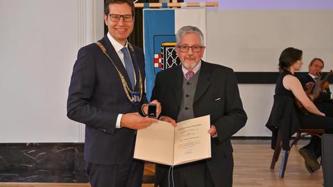 Karl-Josef Schiffer und Oberbürgermeister Thomas Eiskirch bei der Auszeichnung mit dem Ehrenring und der Verleihungsurkunde