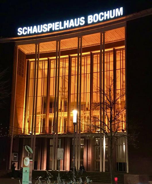 Das Schauspielhaus erstrahlt bei Nacht in orangefarbenem Licht 