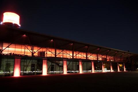 Die Jahrhunderthalle wird in orangefarbenem Licht beleuchtet 