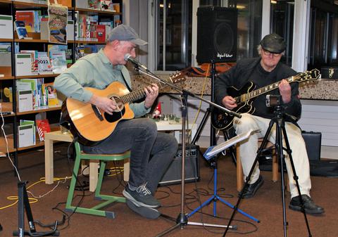 Peter Reidegeld und Franz Weingarten spielen Gitarre in einer Bücherei