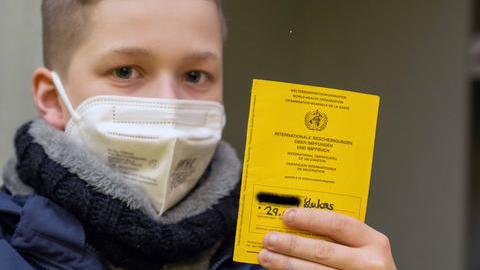 Ein Junge mit seinem Impfpass