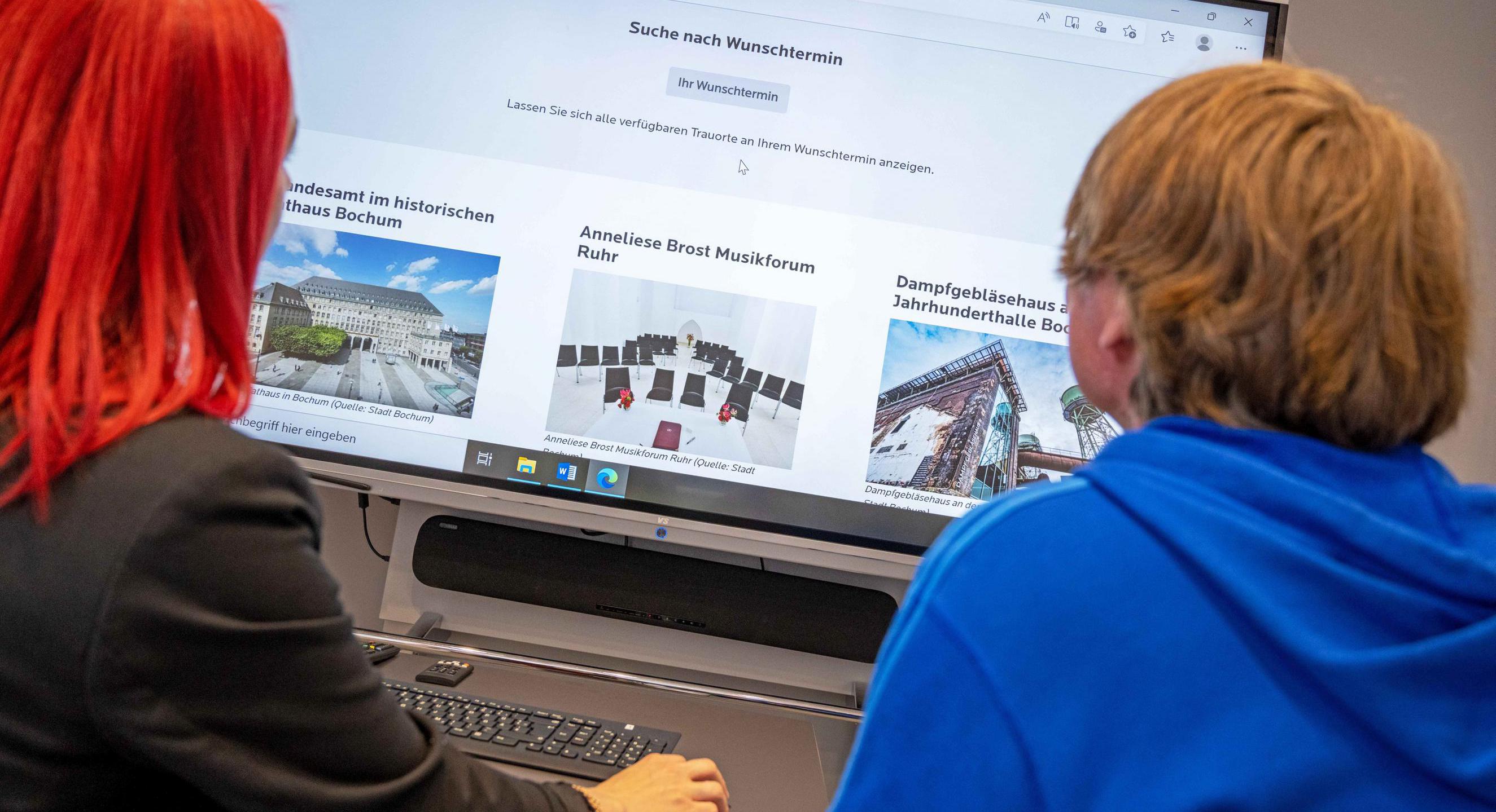 Zwei Personen greifen am Computer auf einen Brautkalender zu. 