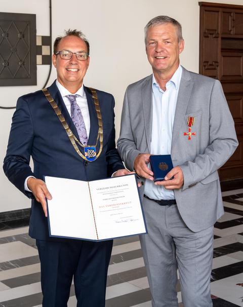 Bürgermeister Sascha Dewender übergibt das Verdienstkreuz an Matthias Ketteler.