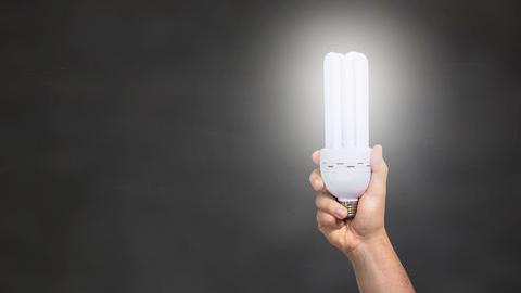 Hand mit Energiesparlampe