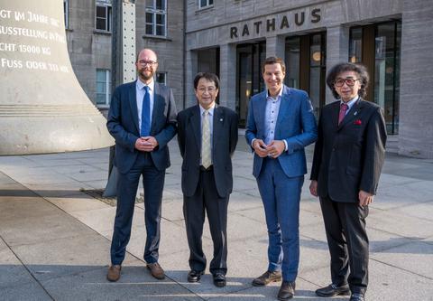 Oberbürgermeister Thomas Eiskirch und Stadtdirektor Sebastian Kopietz empfangen die japanische Delegation aus Tsukuba vor der Rathausglocke