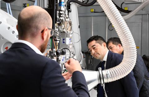 Besuch einer Delegation aus der Partnerstadt Tsukuba beobachtet eine Maschine