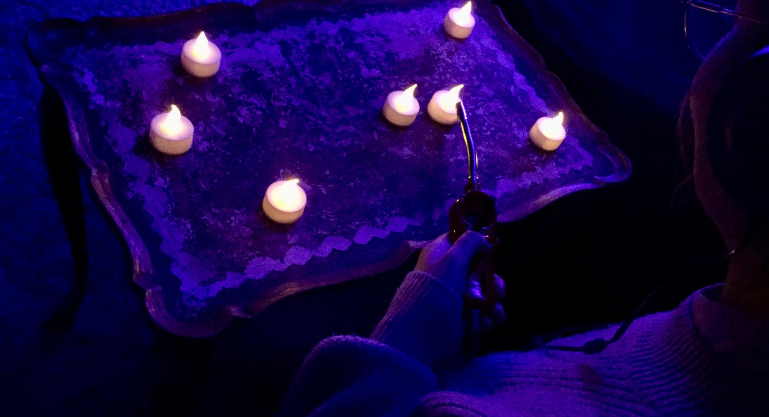 Leuchtende LED-Teelichter auf einem Tisch. Die Teelichter erzeugen bestimmte Klänge.