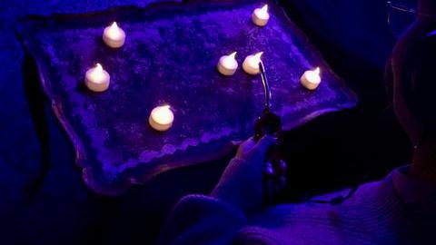 Leuchtende LED-Teelichter auf einem Tisch. Die Teelichter erzeugen bestimmte Klänge.