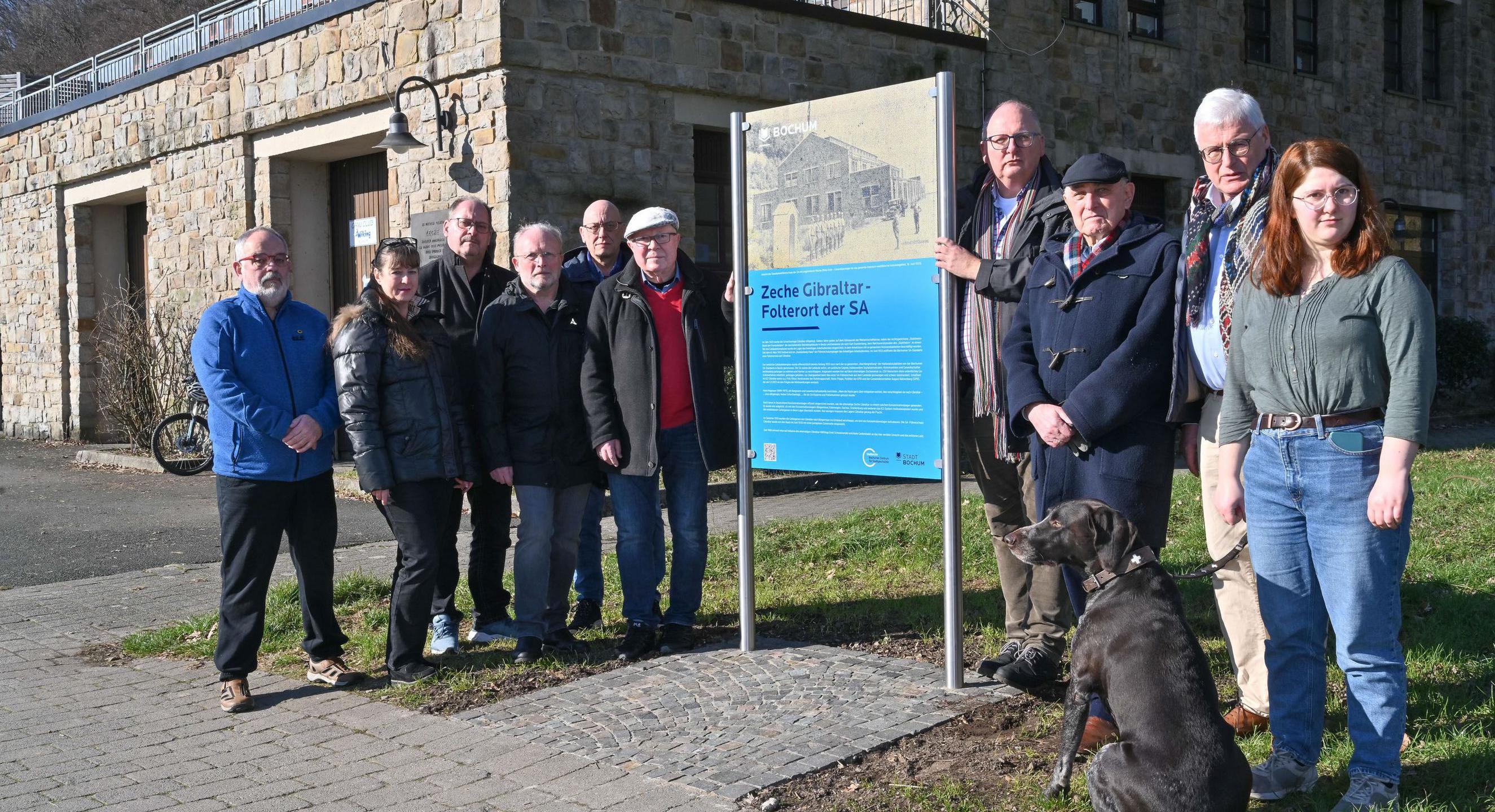 Vertreter der Bezirksvertretung, des Stadtarchivs und des VVN-BdA (Vereinigung der Verfolgten des Naziregimes - Bund der Antifaschistinnen und Antifaschisten) stehen am 14. Februar 2023 an der Erinngerungstafel "Zeche Gibraltar - Folterort der SA" am Kemnader See in Bochum.