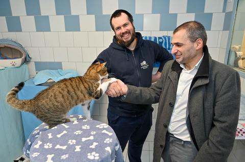 Kater Alfred besiegelt mit seiner Pfote die Kooperation zwischen Julian Behrmann stellvertretend für das Bochumer Tierheim und Meheddiz Gürle stellvertretend für die Stadtbücherei Bochum