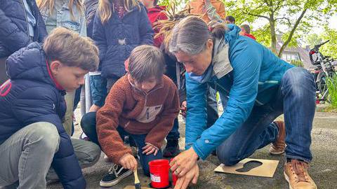 Schüler*innen malen Fußabdrücken auf den Boden.