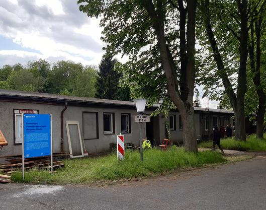 Häuser und Tafel vor ehemaligem Zwangsarbeiterlager 