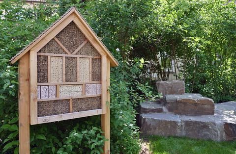 Das Foto zeigt ein Insektenhotel aus Holz. Hier können Insekten nisten und überwintern.