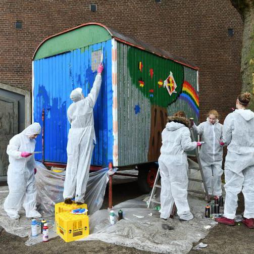 Jugendliche bemalen einen Bauwagen