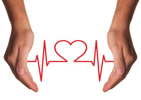  Zwei Hände bilden einen Halbkreis. In der Mitte ist der Sinusrhythmus eines Herzschlags zu sehen. In der Mitte befindet sich ein Herzsymbol.