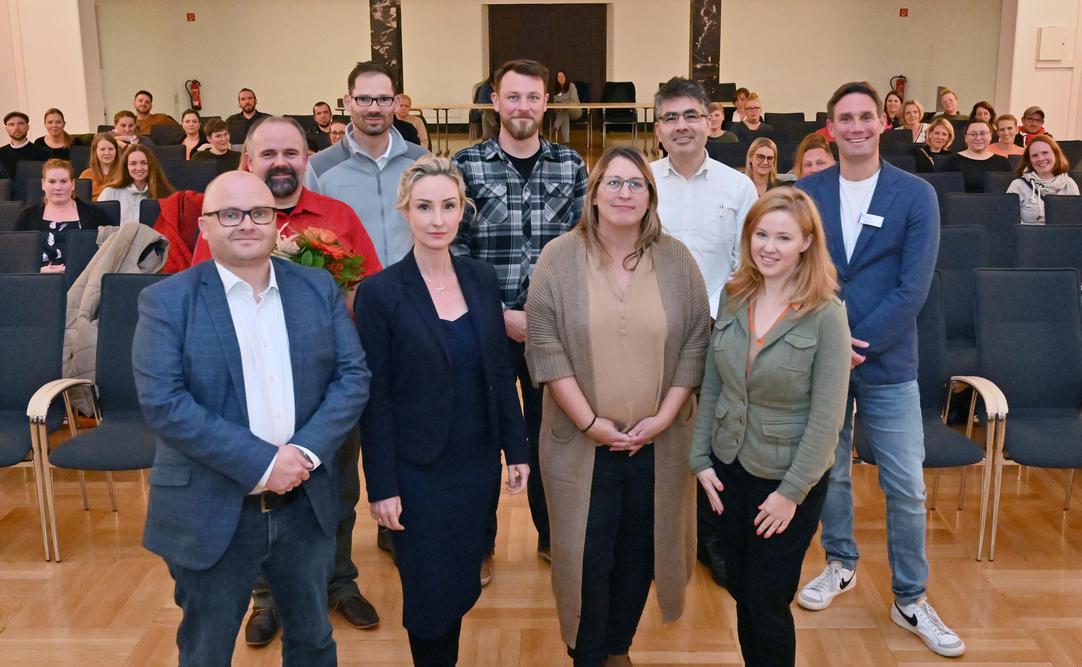 Fabian Wagner, Dr. Antanina Kuljanin, Olivia van de Pavert, Eugenie Männicke. Dahinter: Stefan Uhlmann (Vorsitzender mit Blumen), Norbert Neuser, Max Müller, Dr. Arian Hassib und Christian Papies (Jugendamtsleiter)