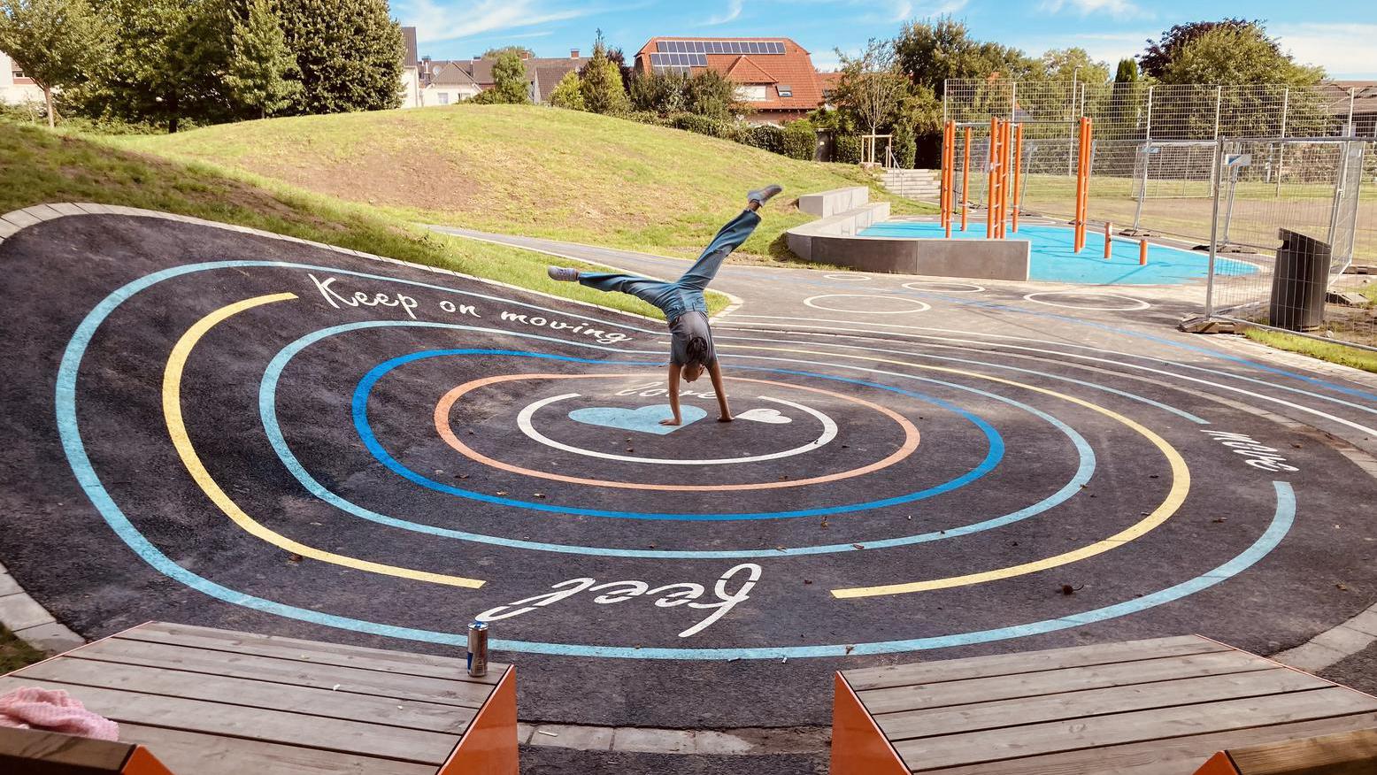 Ein Rad schlagendes Kind auf dem Schulhof