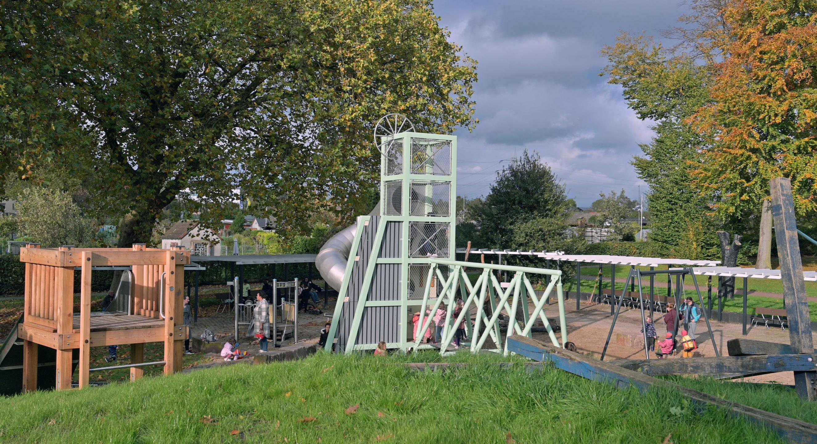 Das Foto zeigt einen Spielplatz mit Klettergerüst und Rutsche.