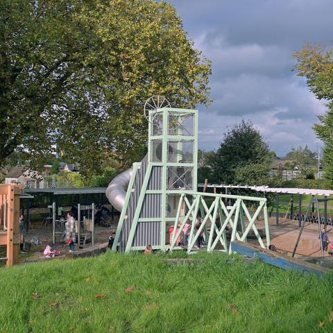Das Foto zeigt einen Spielplatz mit Klettergerüst und Rutsche.