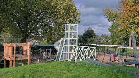 Das Foto zeigt einen Spielplatz mit Klettergerüst und Rutsche.