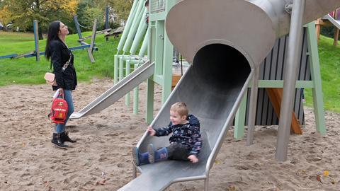 Das Foto zeigt ein Kind, das auf einer Rutsche rutscht.