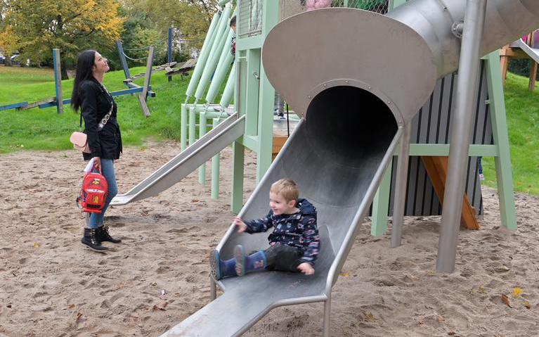 Das Foto zeigt ein Kind, das auf einer Rutsche rutscht.
